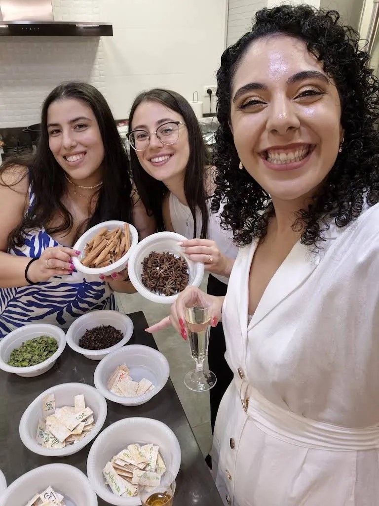 יובל ושתי אורחות מחייכות לסלפי ומחזיקות קערות תבלינים