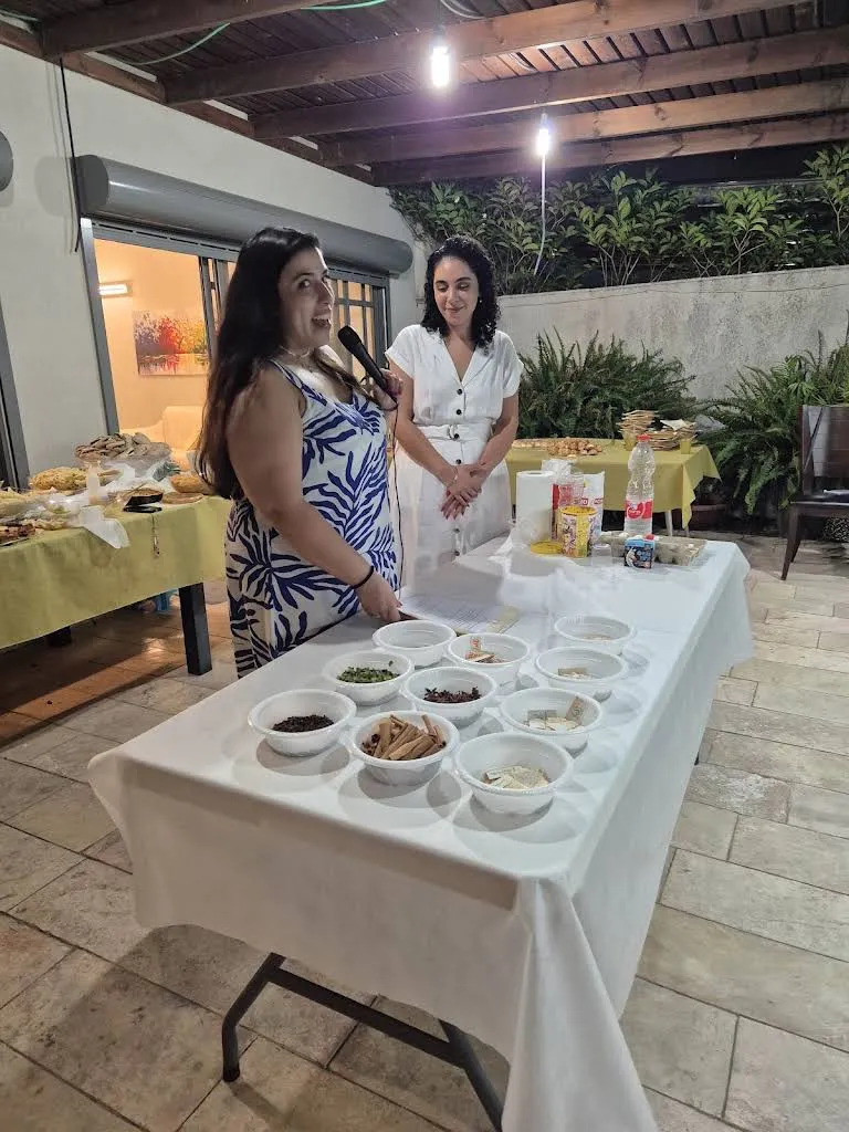 יובל מנחה עם מיקרופון ליד שולחן קערות התבלינים